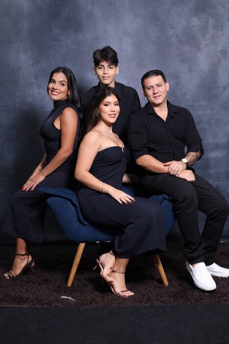 Família em roupa social com a formanda sentada na poltrona