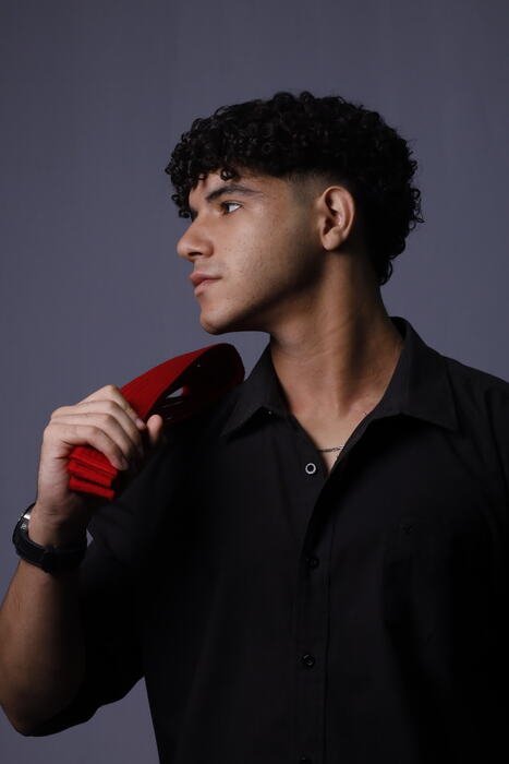 Formando de perfil segurando um objeto vermelho