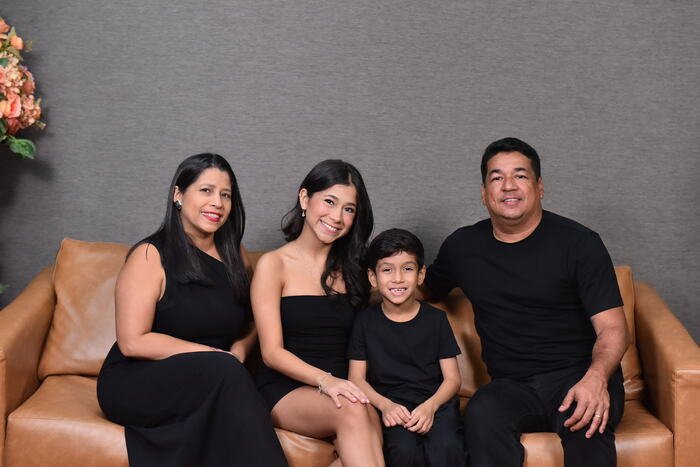 Família sentada em sofá de couro