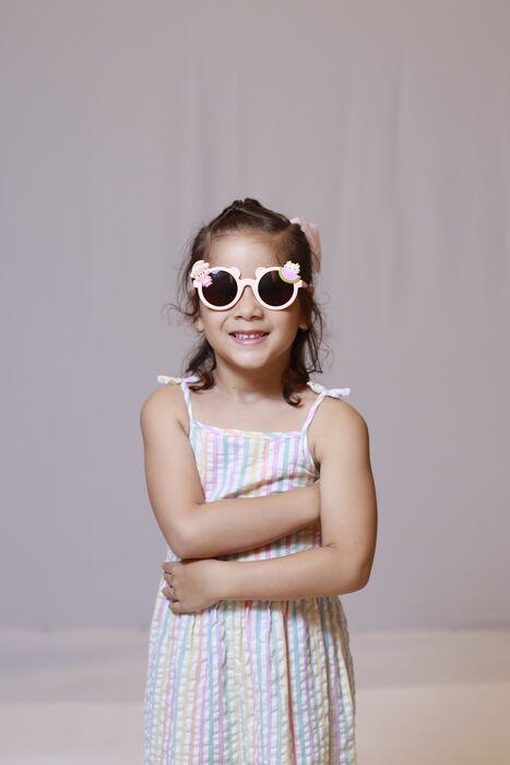 Menina de óculos escuros em fundo claro