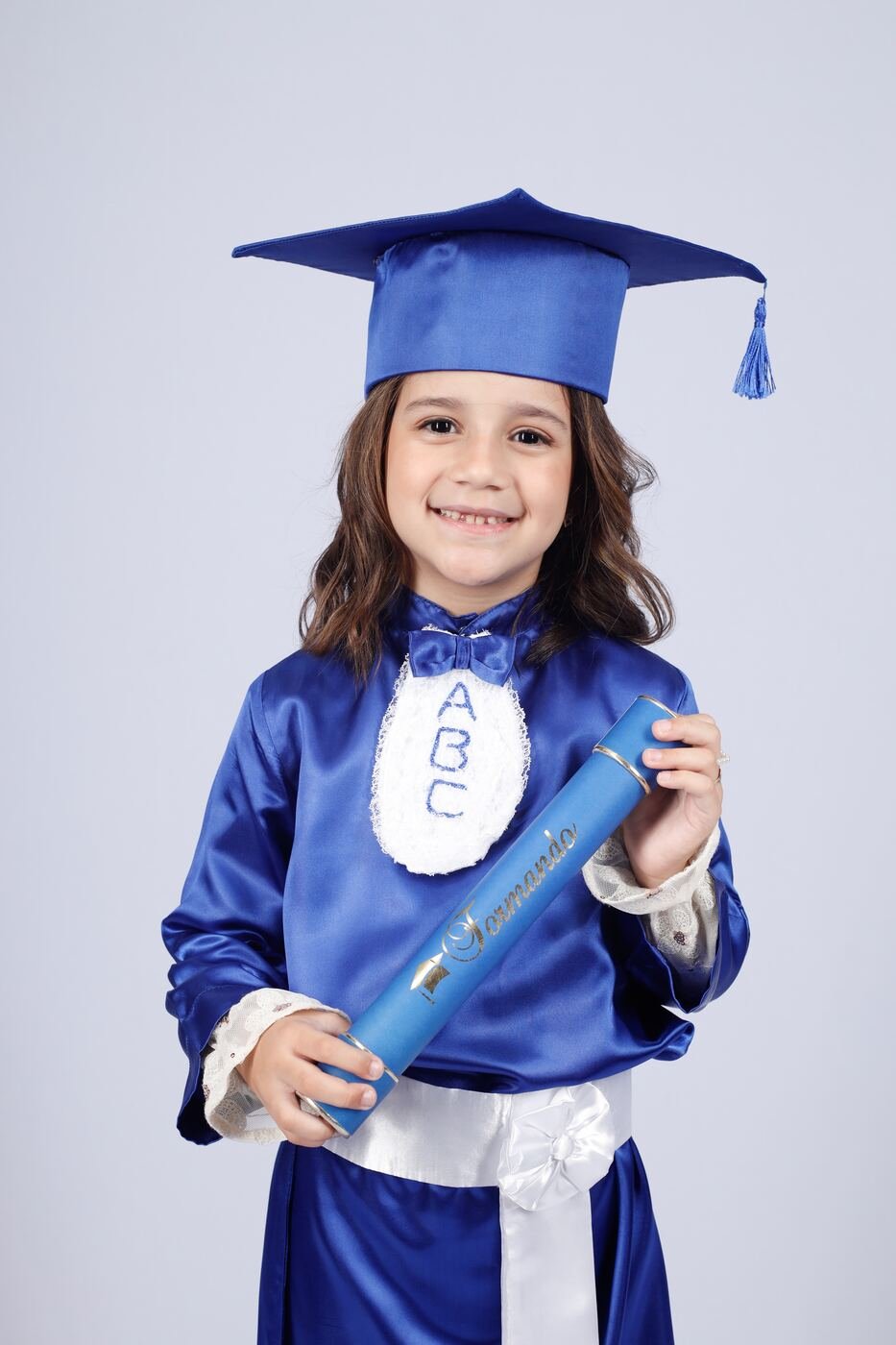 Criança do ABC de beca azul e capelo com o canudo